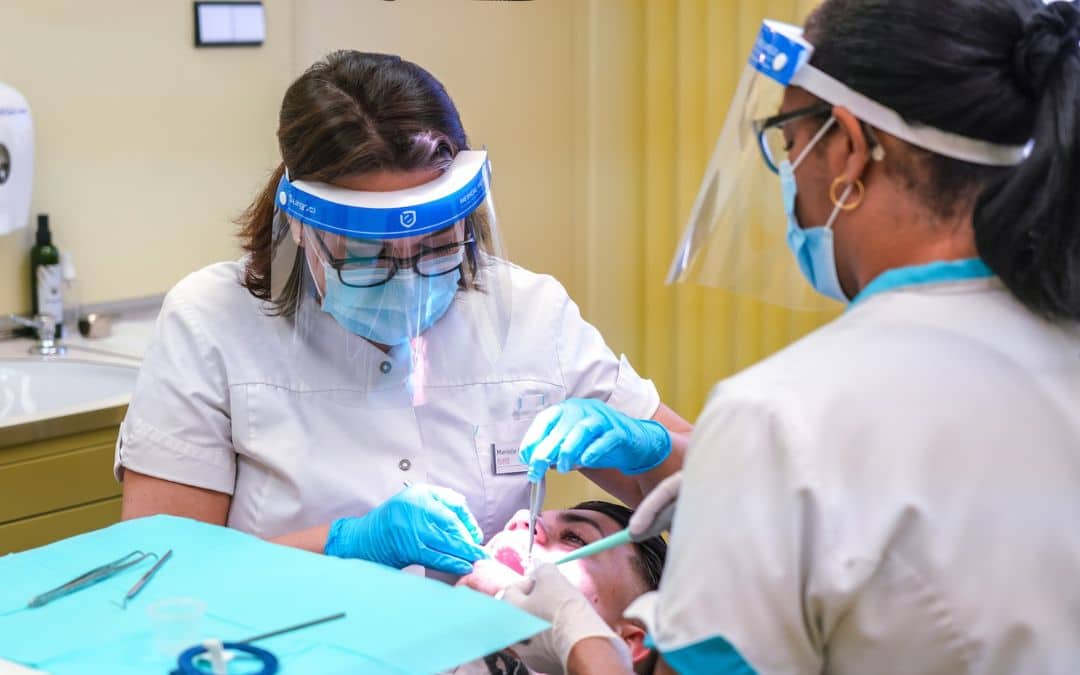 Dental professionals are examining a patient's tooth for an upcoming procedure for dental crowns.